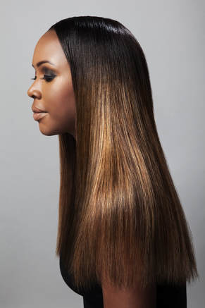 Black model, modelling hair that is long and straight and reaches past her shoulders. Her hair has also been coloured different browns.